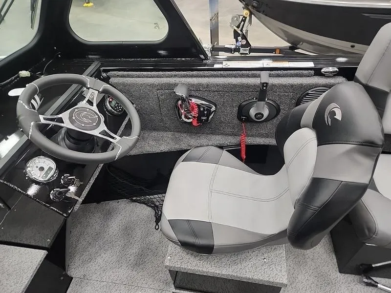 Slide: The Image of 2024 Crestliner 2050 Commander Elite boat interior with steering wheel and seating. - 12