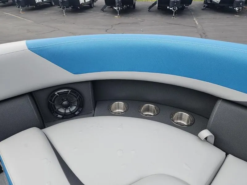 Slide: The Image of 2024 South Bay S224FCR 3.0 boat interior with blue and gray seating, cup holders, and speaker. - 10