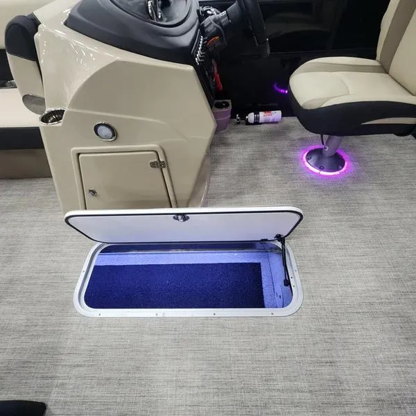 Slide: The Image of 2024 South Bay S224RS 3.0 boat interior with open storage compartment and illuminated seating. - 18