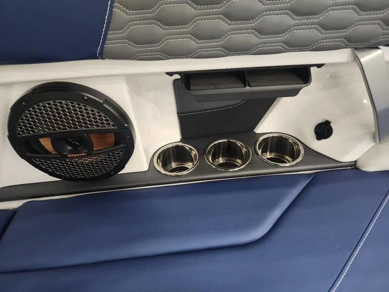 Slide: The Image of 2023 MasterCraft XT22-T interior with speaker, cup holders, and blue upholstery. - 15