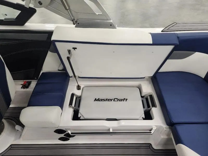 Slide: The Image of 2023 MasterCraft XT22-T boat interior with blue and white seating and storage compartment. - 16