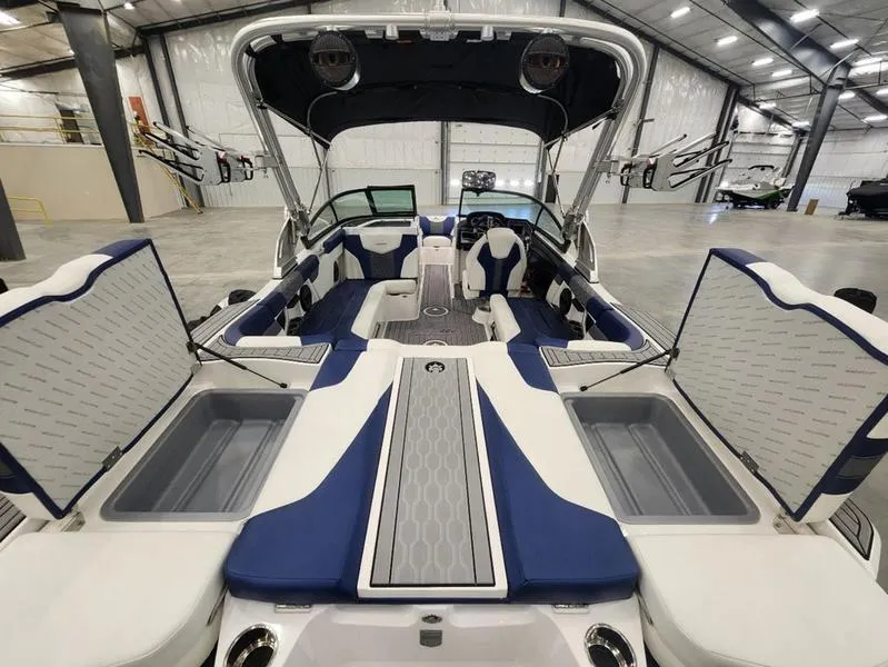 Slide: The Image of 2023 MasterCraft XT22-T boat interior with open storage compartments in a spacious warehouse. - 20