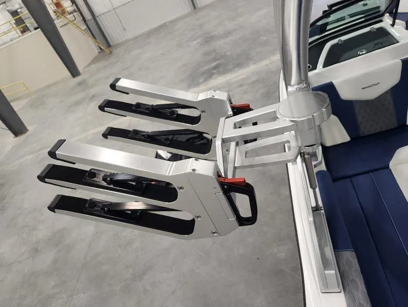 Slide: The Image of 2023 MasterCraft XT22-T boat with sleek wakeboard racks in a modern interior setting. - 23