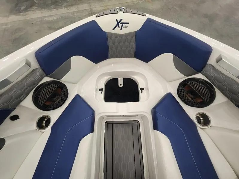 Slide: The Image of 2023 MasterCraft XT22-T boat interior with blue and gray seating and speaker system. - 26