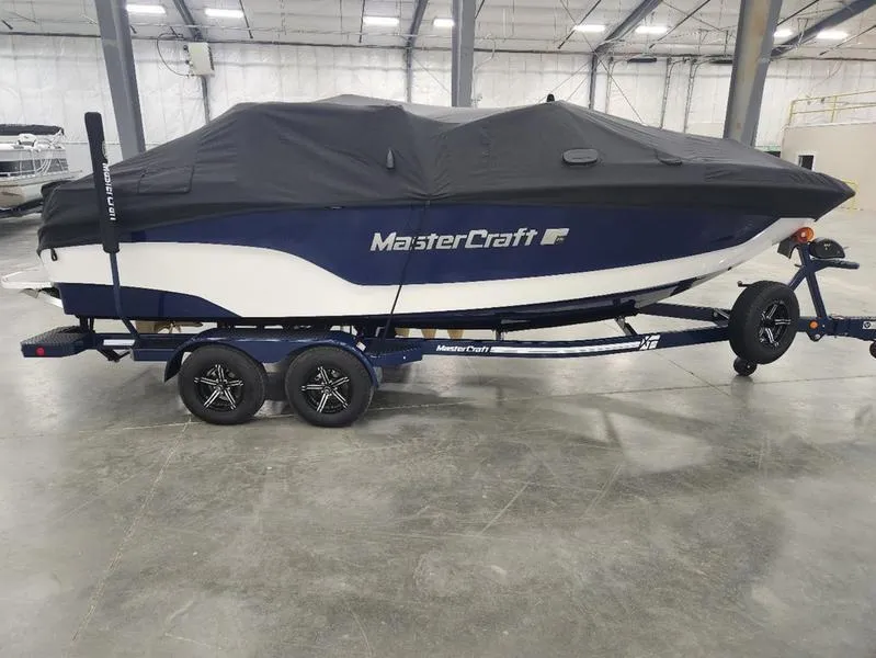 Slide: The Image of 2023 MasterCraft XT22-T boat covered on trailer in warehouse. - 29