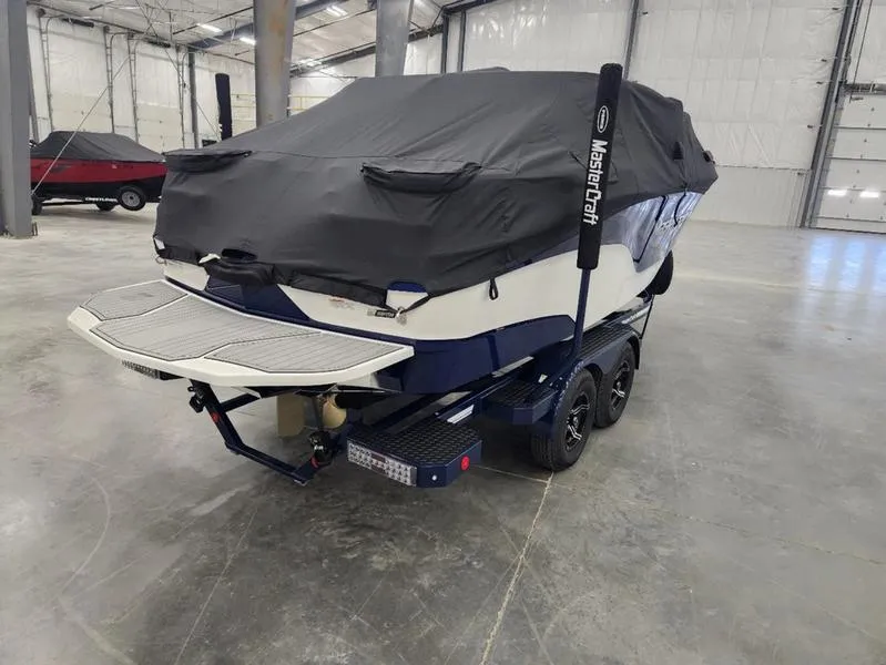 Slide: The Image of 2023 MasterCraft XT22-T boat covered in a warehouse setting. - 31
