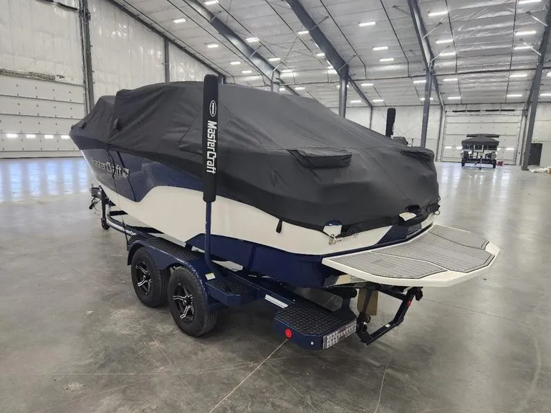 Slide: The Image of 2023 MasterCraft XT22-T boat covered in a warehouse setting. - 32