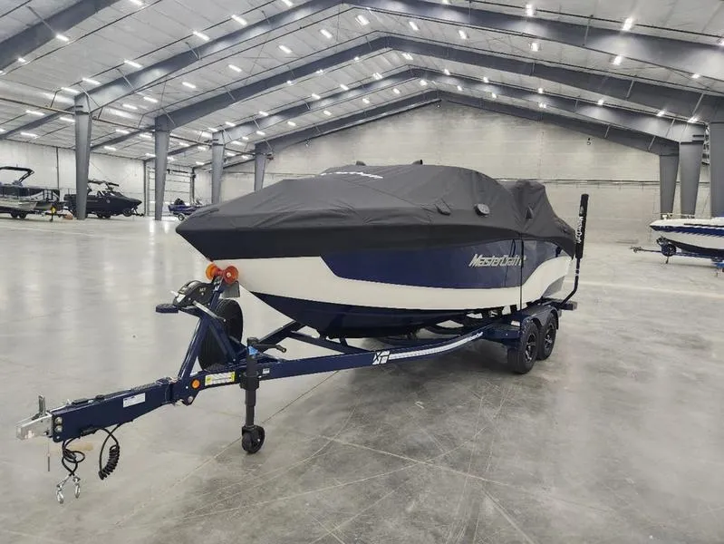 Slide: The Image of 2023 MasterCraft XT22-T boat covered on trailer in spacious indoor storage. - 35