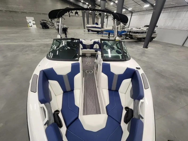 Slide: The Image of 2023 MasterCraft XT22-T boat interior with blue and white seating in a showroom. - 7