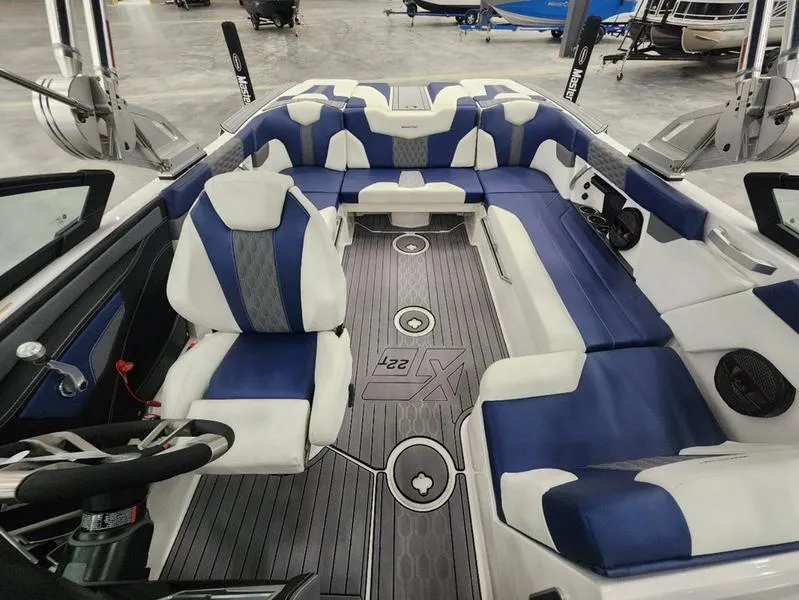 Slide: The Image of 2023 MasterCraft XT22-T boat interior with blue and white seating and sleek design. - 9