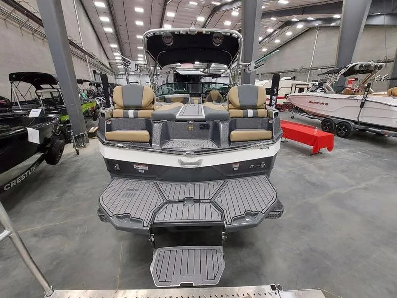 Slide: The Image of 2023 MasterCraft XT23 boat displayed in a showroom, rear view with seating and swim platform. - 10