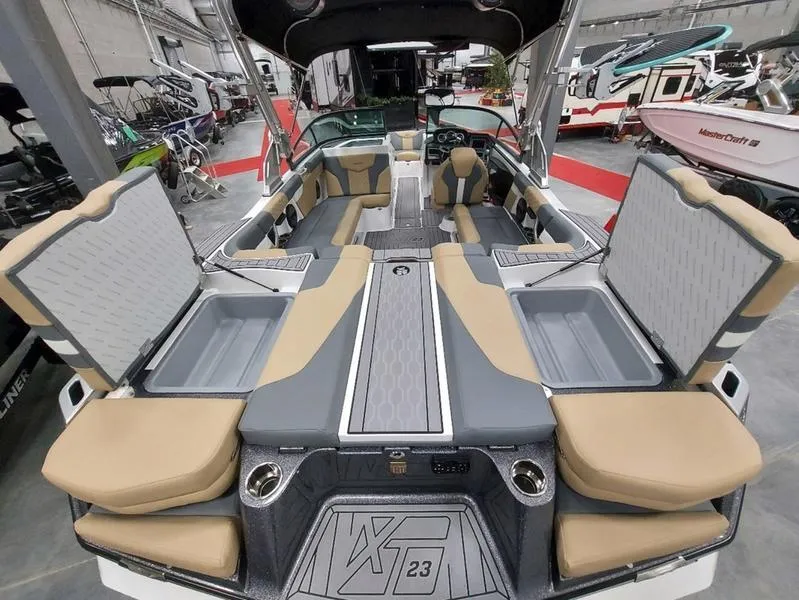 Slide: The Image of 2023 MasterCraft XT23 boat interior with spacious seating and storage compartments. - 13