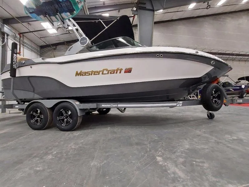 Slide: The Image of 2023 MasterCraft XT23 boat on trailer in indoor showroom. - 2