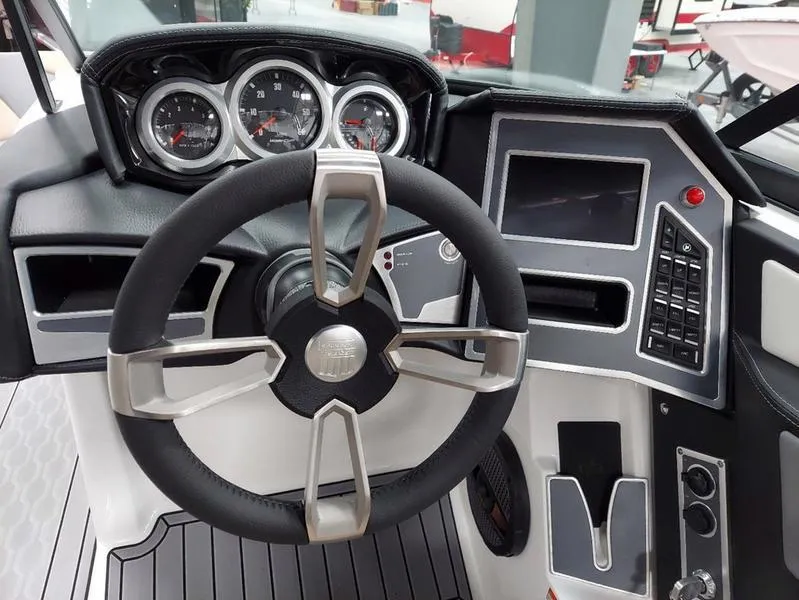 Slide: The Image of 2023 MasterCraft XT23 boat dashboard with steering wheel and control panel. - 20
