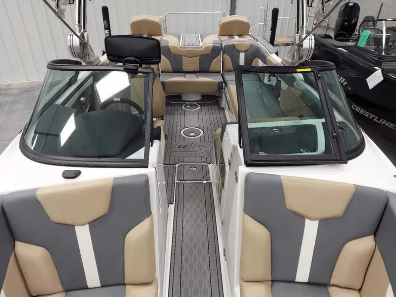 Slide: The Image of 2023 MasterCraft XT23 boat interior with beige and gray seating. - 26