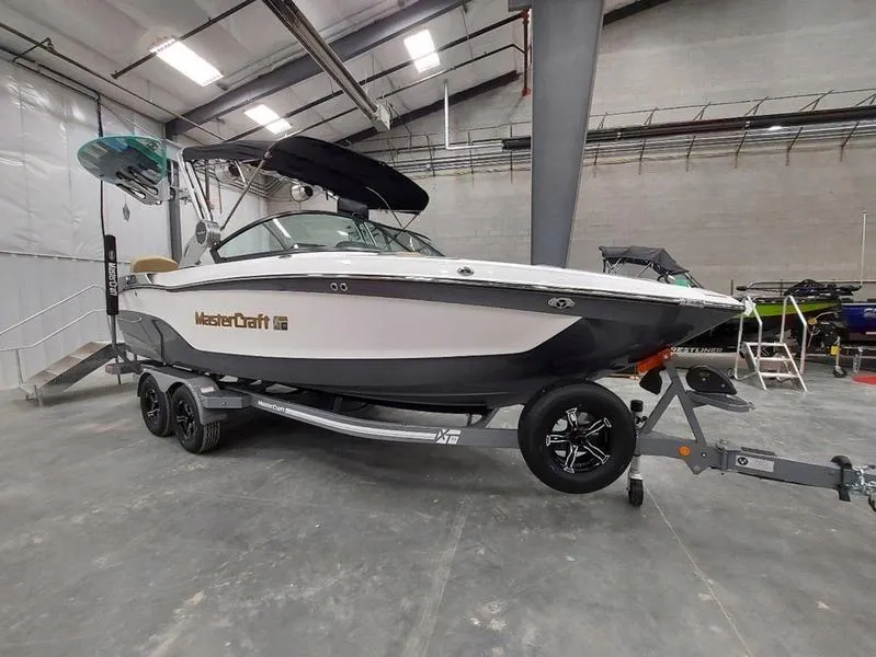 Slide: The Image of 2023 MasterCraft XT23 boat on trailer in indoor showroom. - 3