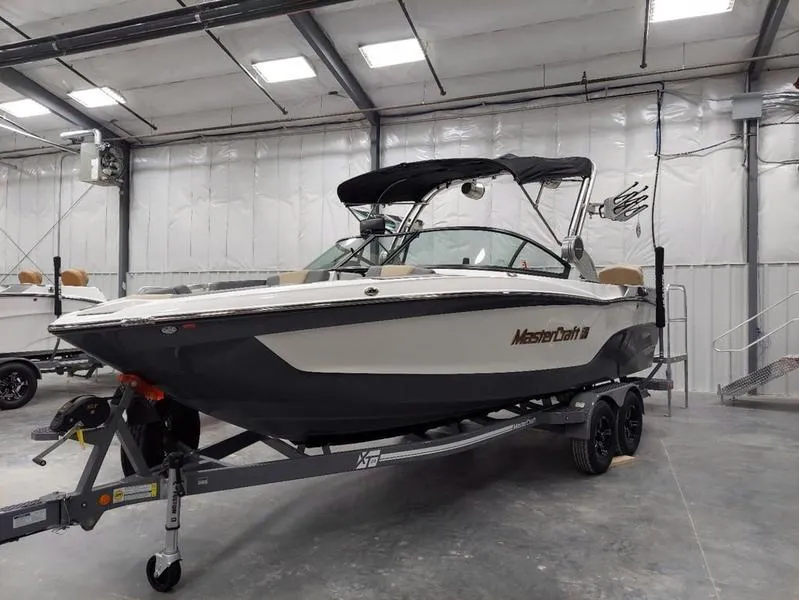 Slide: The Image of 2023 MasterCraft XT23 boat in a showroom on a trailer. - 4