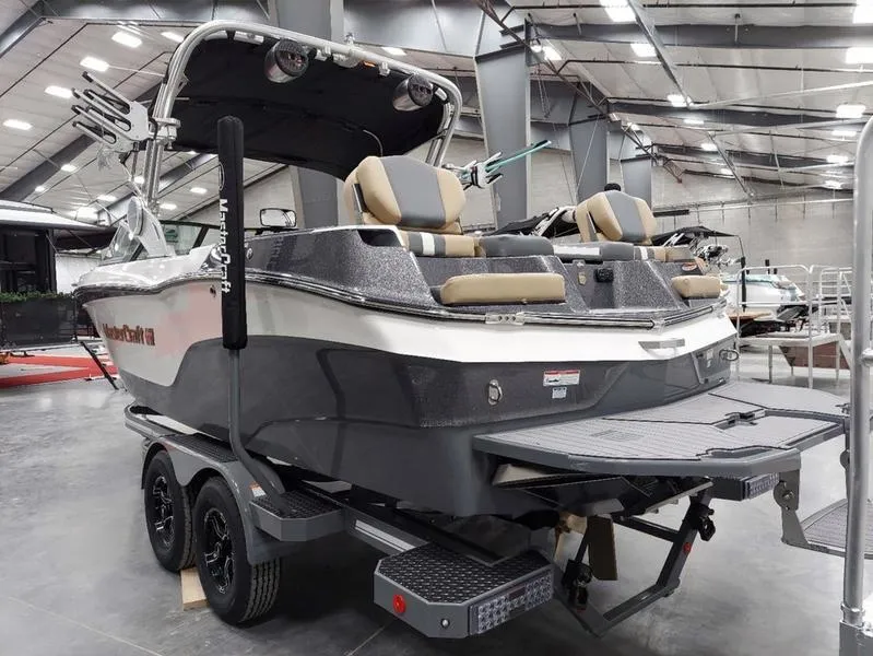 Slide: The Image of 2023 MasterCraft XT23 boat in showroom, featuring sleek design and dual seating. - 8