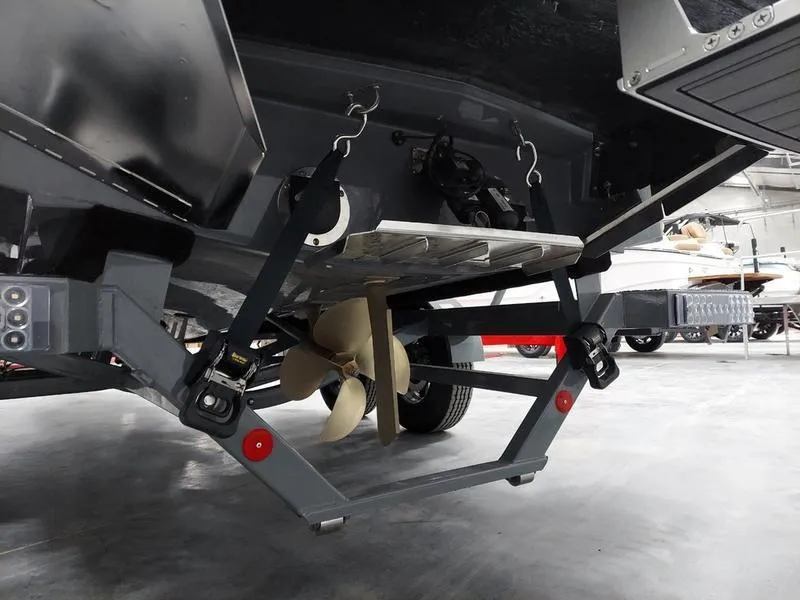 Slide: The Image of 2023 MasterCraft XT23 boat trailer with propeller and hitch details in showroom. - 9