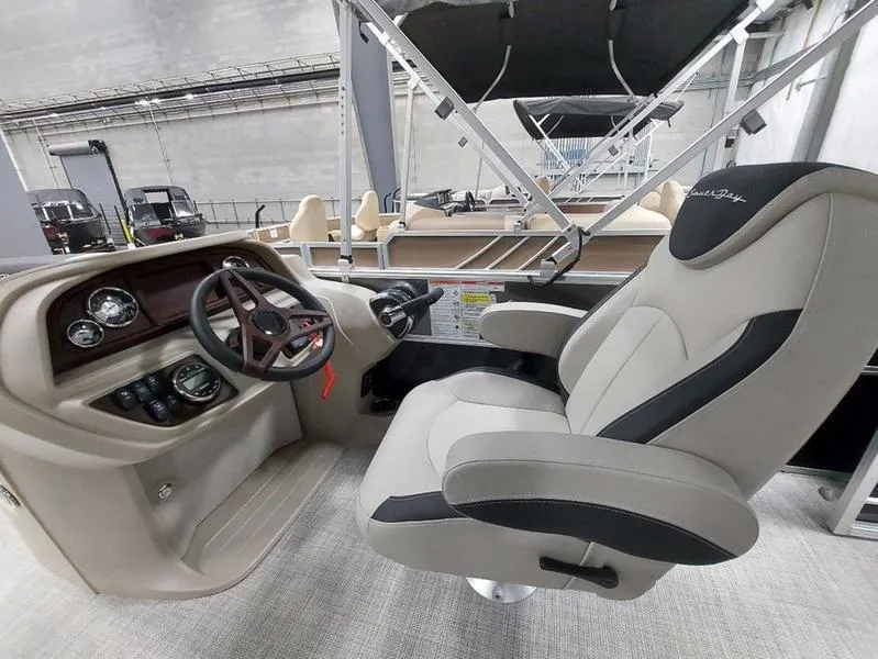 Slide: The Image of 2023 South Bay 220CR LE 25" boat interior with captain's chair and dashboard controls. - 11