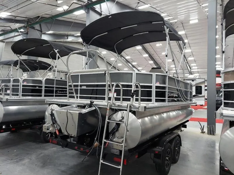 Slide: The Image of 2023 South Bay 220CR LE 25" pontoon boat in showroom, featuring sleek design and canopy. - 3