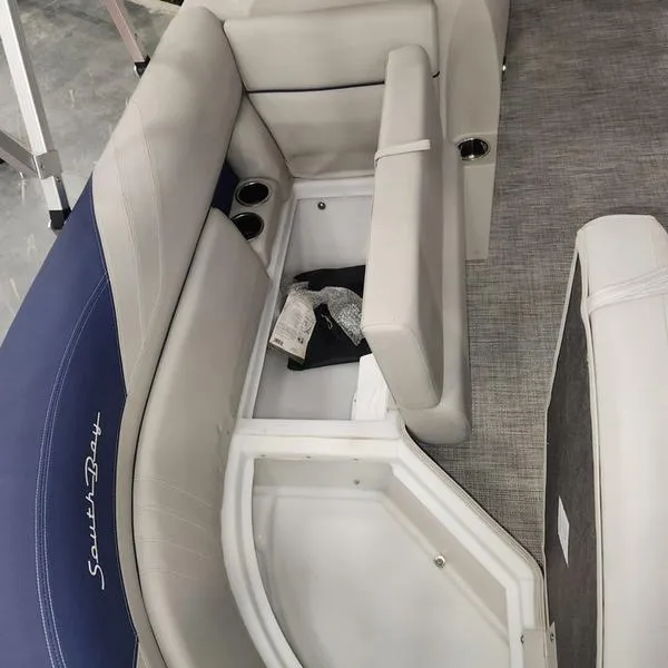 Slide: The Image of 2023 South Bay 224RS LE boat interior with storage compartment and cup holders. - 13
