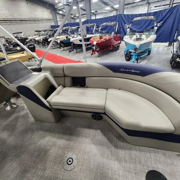 Slide: The Image of 2023 South Bay 224RS LE pontoon boat interior with luxurious seating in showroom. - 24