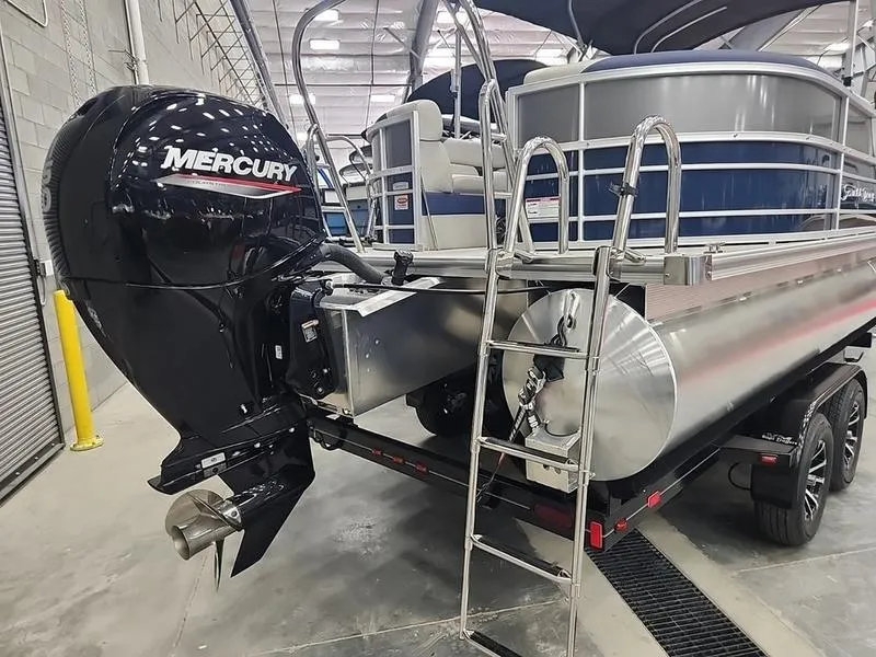 Slide: The Image of 2023 South Bay 224RS LE pontoon boat with Mercury outboard motor in a showroom. - 26