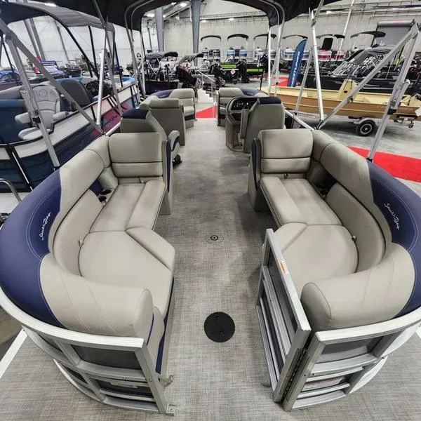 Slide: The Image of 2023 South Bay 224RS LE pontoon boat interior with plush seating in showroom. - 8