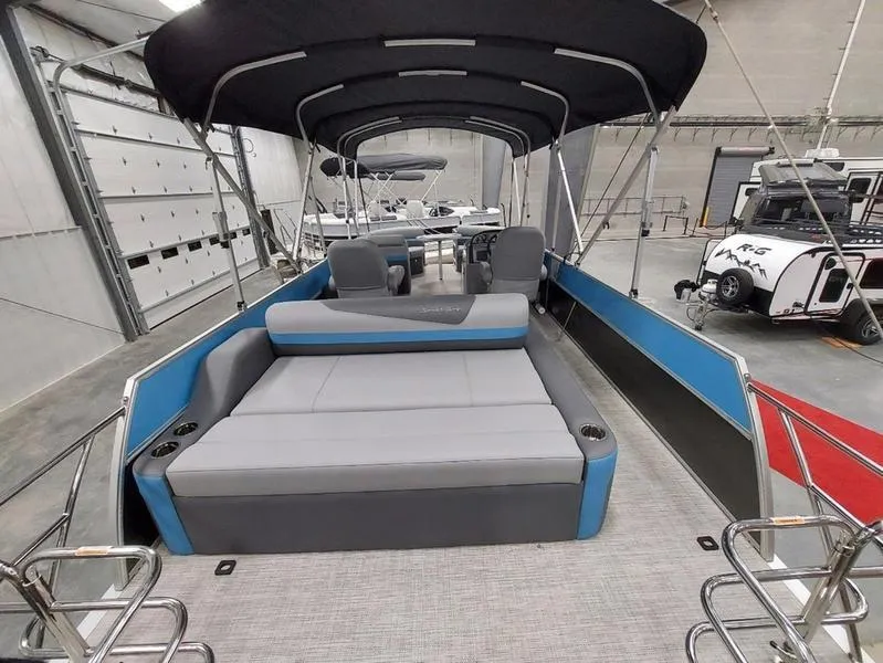 Slide: The Image of 2023 South Bay S224 UL 3.0 pontoon boat with spacious seating and canopy in a showroom. - 11