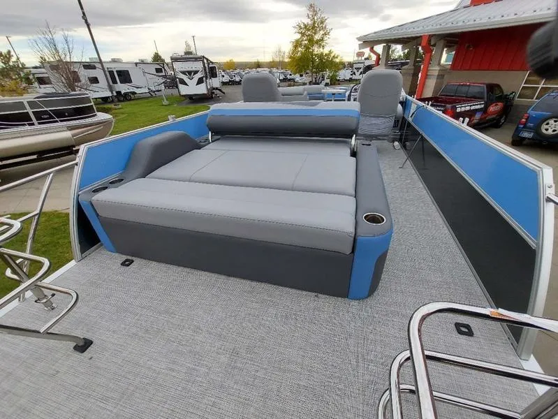 Slide: The Image of 2023 South Bay S224 UL 3.0 pontoon boat with gray and blue seating, parked outdoors. - 12
