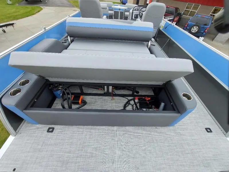 Slide: The Image of 2023 South Bay S224 UL 3.0 boat with open storage compartment and gray seating. - 13