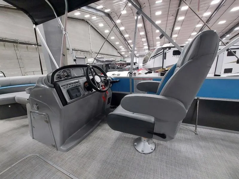 Slide: The Image of Interior of 2023 South Bay S224 UL 3.0 pontoon boat, featuring helm and captain's chair. - 16
