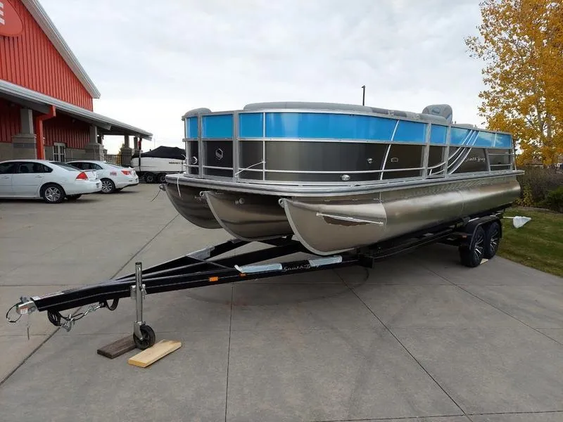 Slide: The Image of 2023 South Bay S224 UL 3.0 pontoon boat on trailer, parked outdoors. - 6