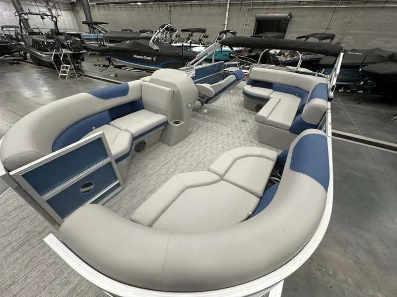 Slide: The Image of 2025 South Bay 222FCRLE pontoon boat interior with plush seating in showroom. - 8