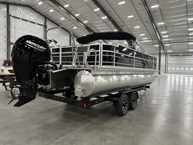 Slide: The Image of 2025 South Bay 224FCRLE pontoon boat with Mercury engine in a spacious indoor facility. - 4