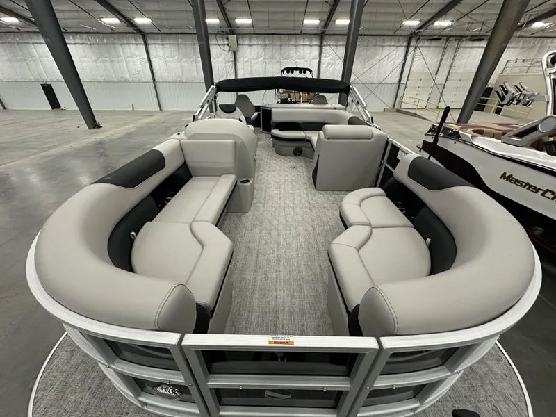 Slide: The Image of 2025 South Bay 224FCRLE pontoon boat with spacious seating in a showroom. - 6