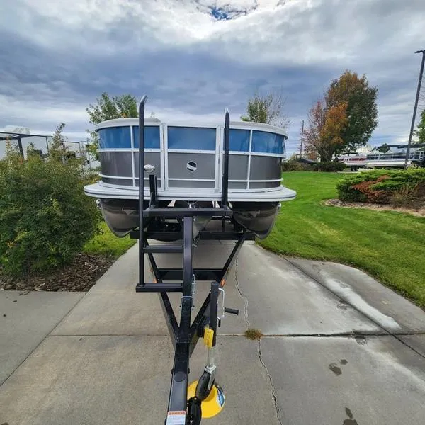 Slide: The Image of 2024 South Bay 222RS LE 2.75 pontoon boat on trailer, parked outdoors. - 9