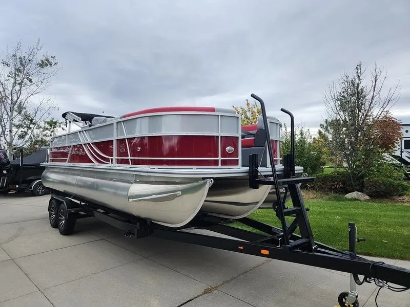Slide: The Image of 2024 South Bay S224FCR 2.75 pontoon boat on trailer, parked outdoors. - 1