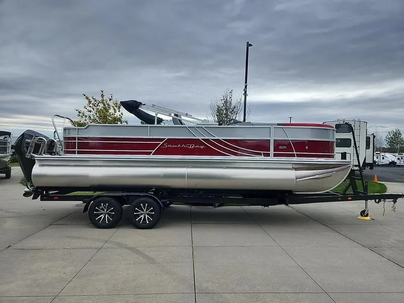 Slide: The Image of 2024 South Bay S224FCR 2.75 pontoon boat on trailer, overcast sky. - 2