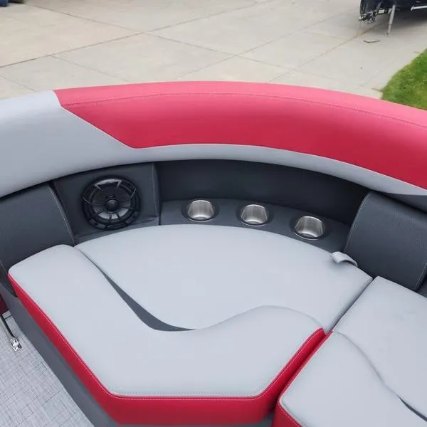 Slide: The Image of 2024 South Bay S224FCR 2.75 boat interior with red and gray seating, cup holders, and speaker. - 20