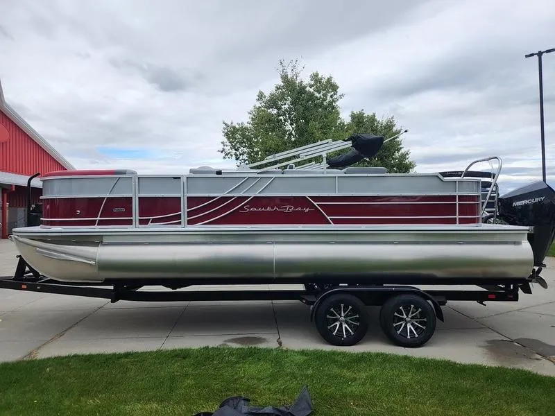 Slide: The Image of 2024 South Bay S224FCR 2.75 pontoon boat on trailer, red and silver design. - 7