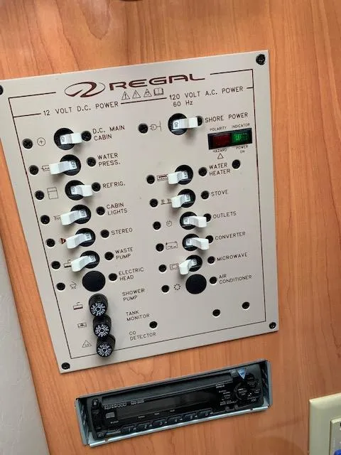 Slide: The Image of Control panel of a 1999 Regal 2850 LSC boat with various switches and indicators. - 13