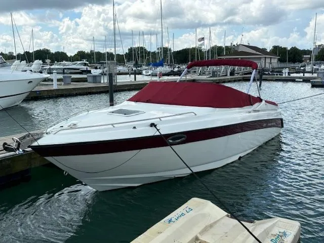 Slide: The Image of 1999 Regal 2850 LSC boat docked at marina with red cover. - 2