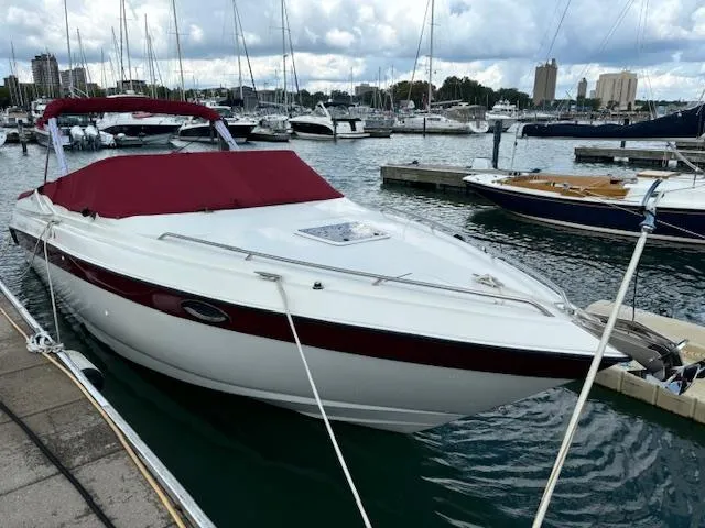 Slide: The Image of 1999 Regal 2850 LSC boat docked in marina with red cover and calm waters. - 3