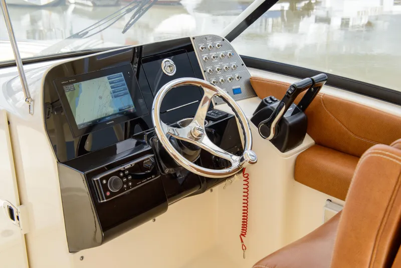 Slide: The Image of 2026 Scout 255 Dorado boat dashboard with steering wheel and navigation system. - 12