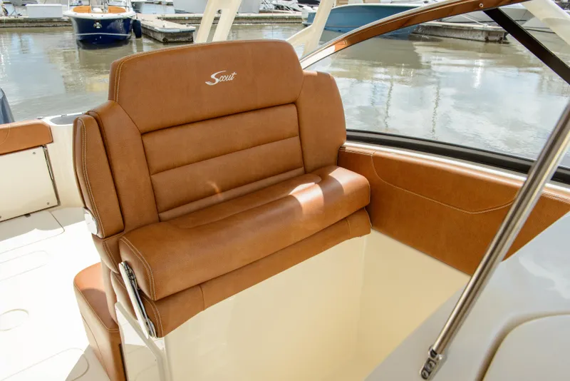 Slide: The Image of 2026 Scout 255 Dorado boat with luxurious tan leather seating at a marina. - 15