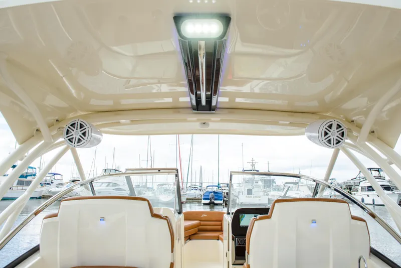 Slide: The Image of 2026 Scout 255 Dorado boat interior with speakers and marina view. - 18