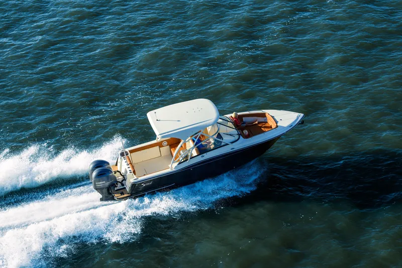 Slide: The Image of 2026 Scout 255 Dorado boat cruising on open water, showcasing sleek design and powerful engines. - 2