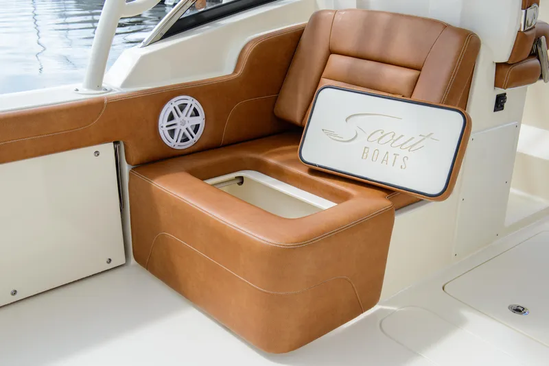 Slide: The Image of 2026 Scout 255 Dorado boat interior with tan leather seating and storage compartment. - 22